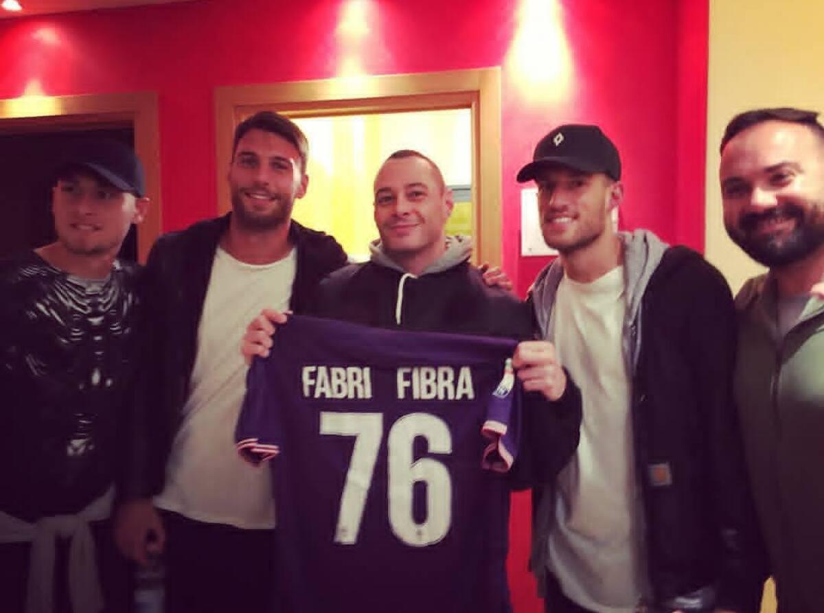 I giocatori viola vanno a vedere Fabri Fibra a Firenze e gli regalano una maglia della Fiorentina - 