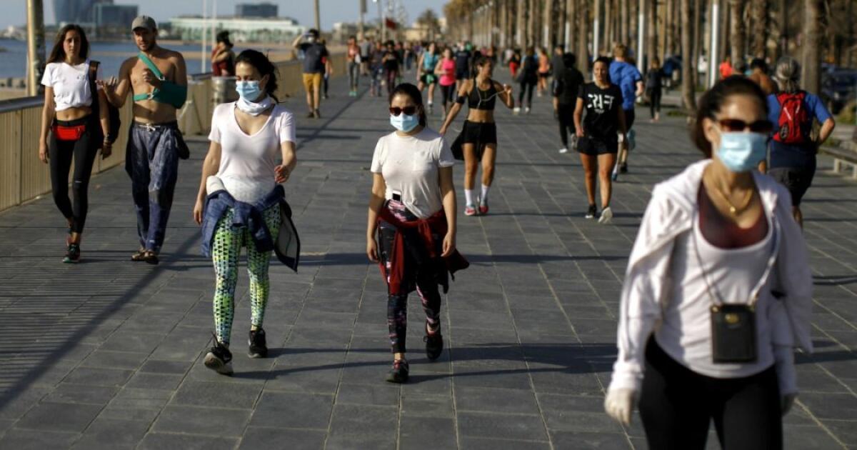 Coronavirus, la certificazione servirà solo per uscire dalla regione. I parrucchieri pronti a riaprire - People walk along a seafront promenade in Barcelona, Spain, Saturday, May 2, 2020. Spaniards have filled the streets of the country to do exercise for the first time after seven weeks of confinement in their homes to fight the coronavirus pandemic. P
