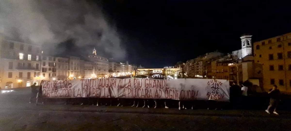 Gli ultras viola nella foto pubblicata dalla pagina Facebook Fuori dal Coro che mostrano il loro striscione per il compleanno della Fiorentina. Alle spalle Ponte Vecchio