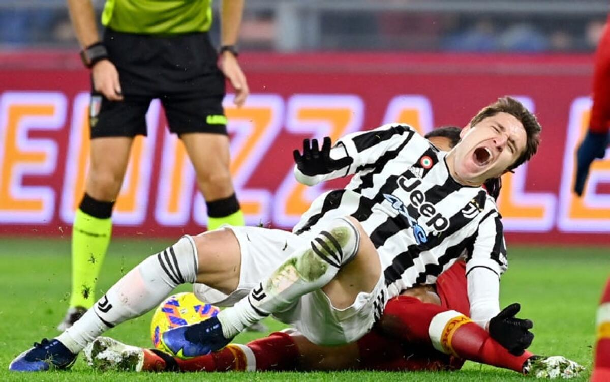 Ora è ufficiale, la Juventus annuncia per Chiesa l'infortunio al legamento crociato. Stagione finita - Juventus' Italian forward Federico Chiesa (front) is tackled during the Serie A football match beetween AS Roma and Juventus at the Olympic stadium in Rome on January 9, 2022. (Photo by Alberto PIZZOLI / AFP) (Photo by ALBERTO PIZZOLI/AFP via Getty I