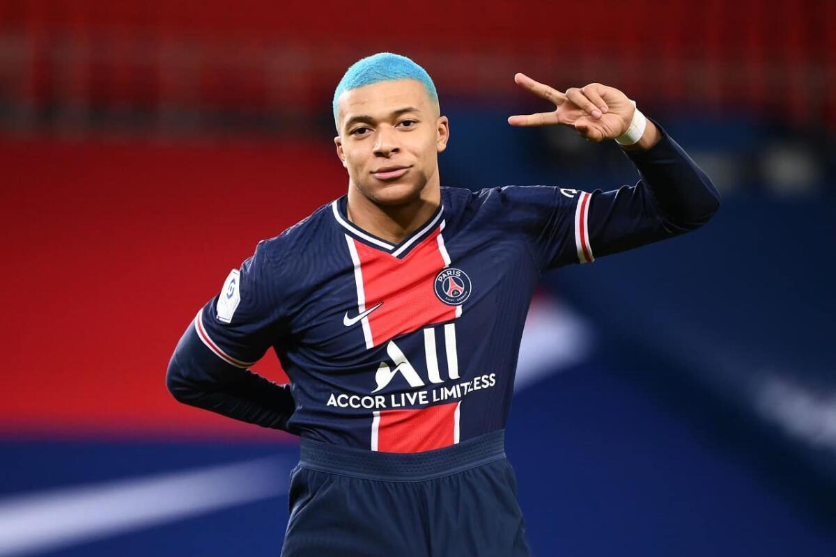 Mbappé rinnova con il Psg a 100 milioni di euro l'anno e bonus alla firma di 300 milioni - Paris Saint-Germain's French forward Kylian Mbappe, with blue hair, flashes the "V" for victory, during the French L1 football match between Paris-Saint Germain (PSG) and FC Lorient at The Parc des Princes Stadium in Paris on December 16, 2020. (Phot